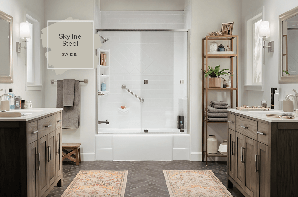 A bathtub stands between two vanities on each side of the bathroom