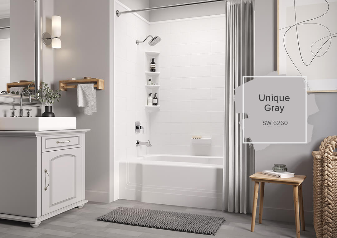 A grey bathroom with the focus on a white acrylic tub